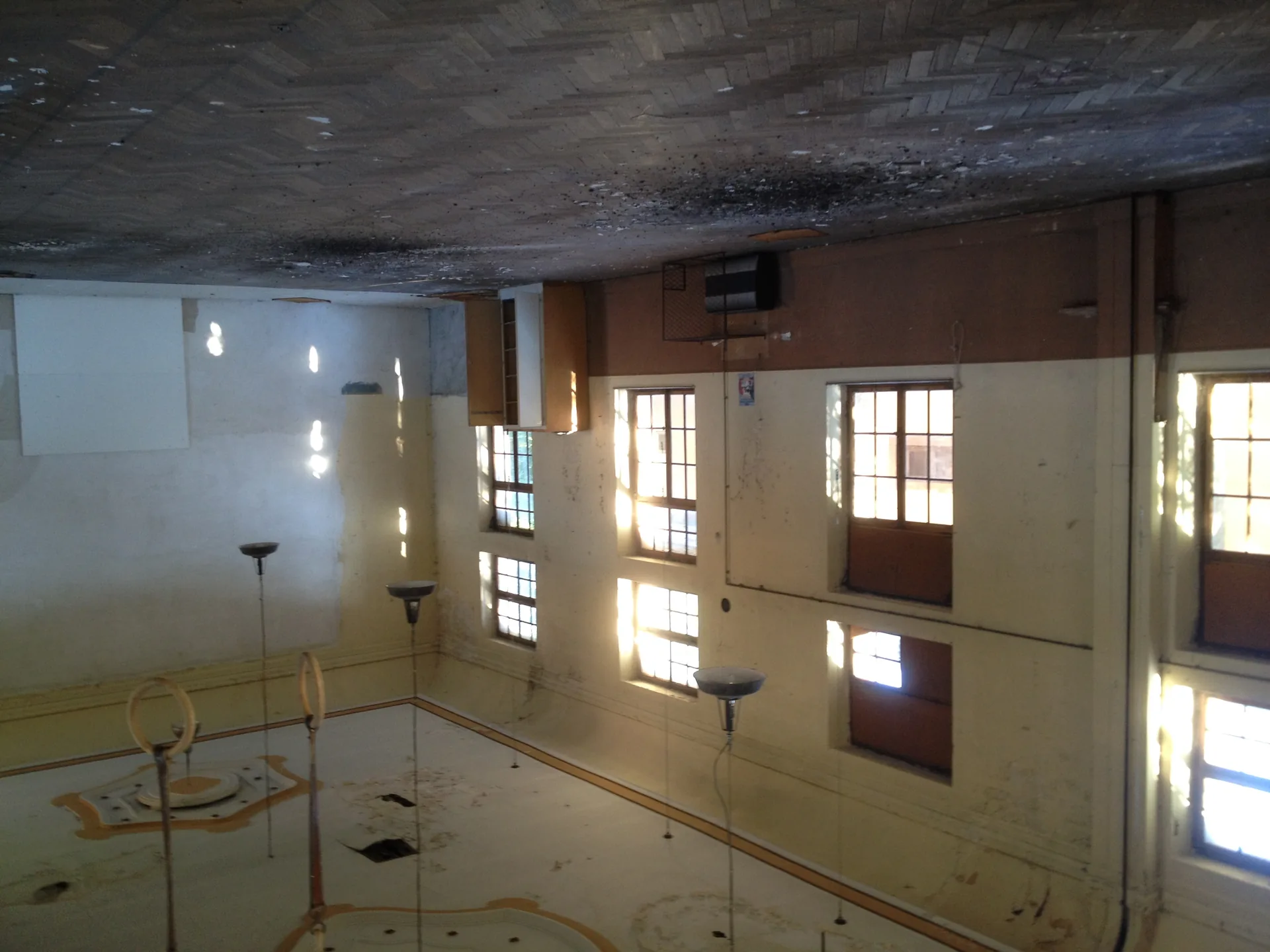 Grande salle de l'ancien théâtre avant rénovation — parquet et lumière naturelle